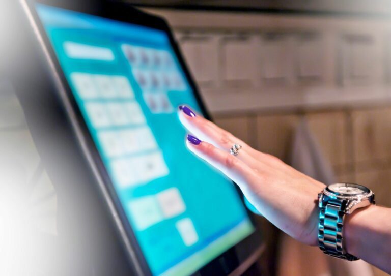 pessoa comprando utilizando uma tela touchscreen para ilustrar a tecnologia no varejo