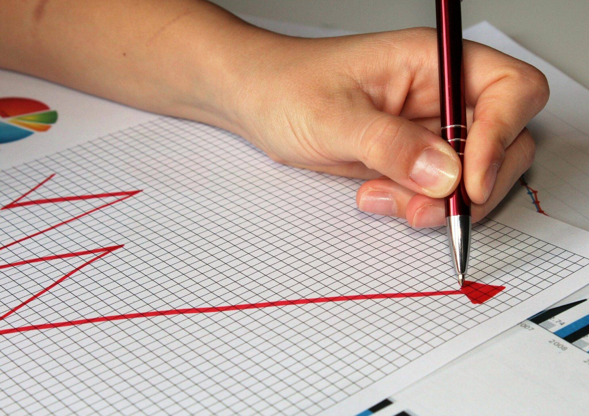 pessoa desenhando um gráfico em crescimento para ilustrar o aumento de margem de lucro