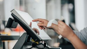 Pessoa teclando tela no mercado para ilustrar a diferença no uso da tecnologia entre varejo 4.0 x varejo 5.0