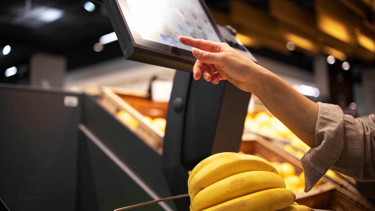 imagem de pessoa realizando o self checkout no supermercado