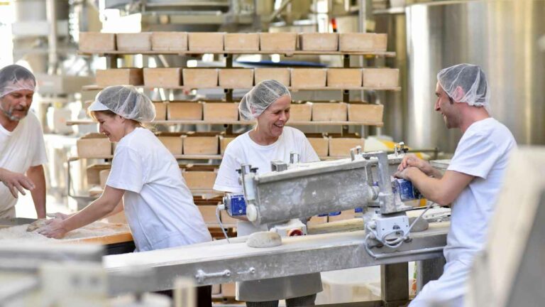 pessoas trabalhando em indústria de alimentos para ilustrar o ambiente em que podem ser calculados os custos de produção