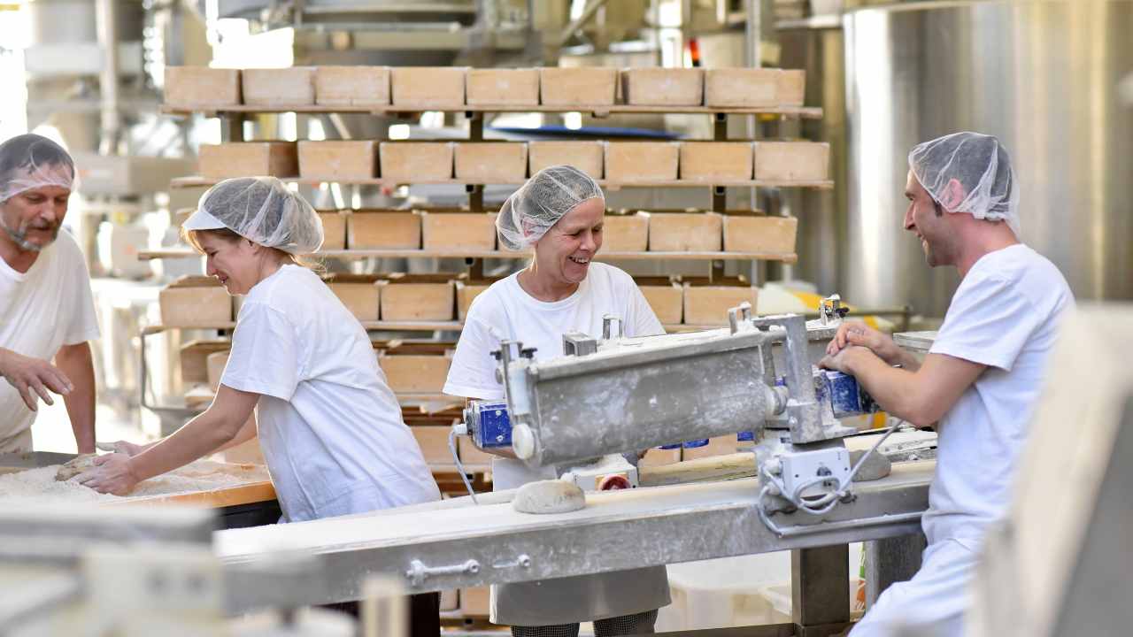 pessoas trabalhando em indústria de alimentos para ilustrar o ambiente em que podem ser calculados os custos de produção