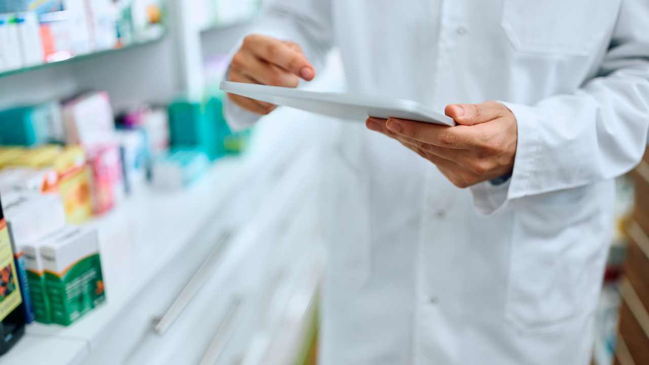 pessoa analisando dados na farmácia para ilustrar o acompanhamento do reajuste cmed de preços de medicamentos
